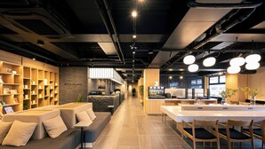 A modern interior with a sofa, dining area, and kitchen. - HOTEL FUJi TORiiGATE (Fujiyoshida)