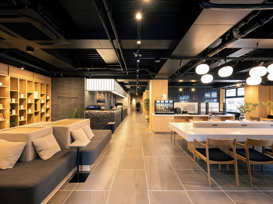 A modern interior with a sofa, dining area, and kitchen.