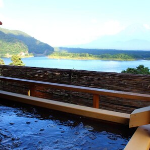 Eine Holterrasse mit Blick auf einen stillen See, im Hintergrund Berge.