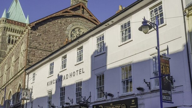 L'hôtel Kings Head se distingue par sa façade de style traditionnel, son bar Regency 69 et une tour de l'horloge qui se dresse à l'arrière-plan.