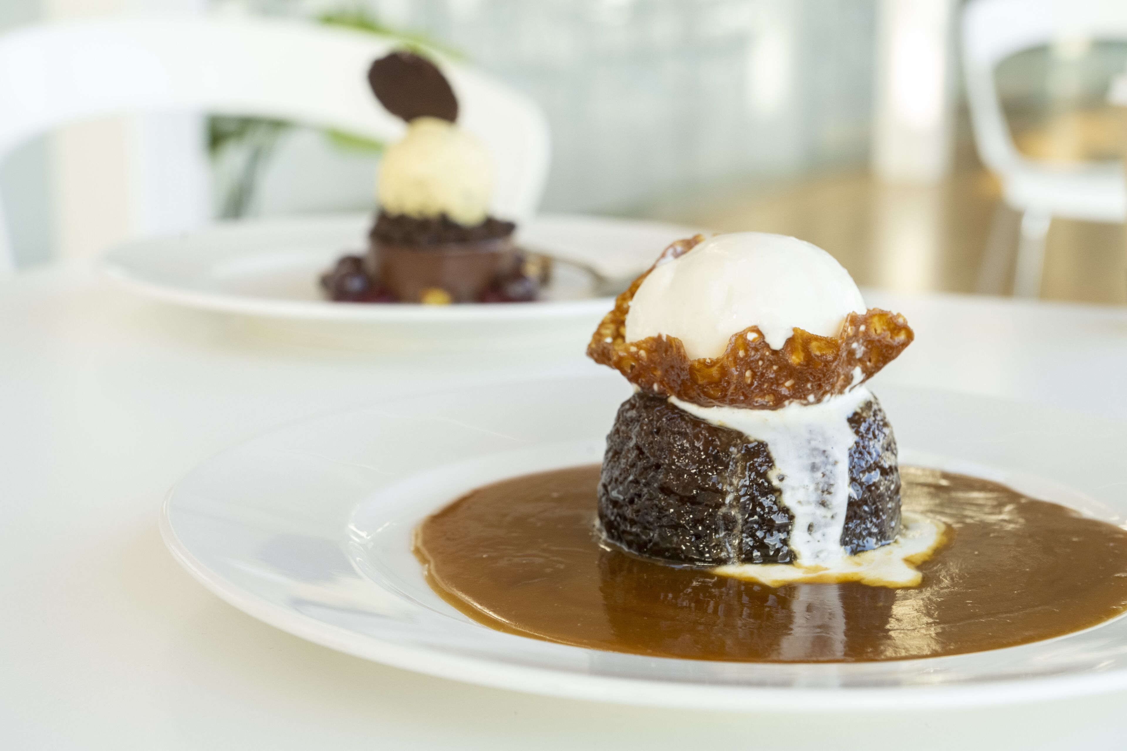 A dessert on a white plate with a caramel sauce.