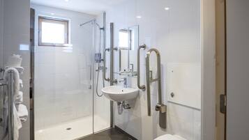 Une salle de bain moderne avec une douche à parois de verre, un lavabo blanc et des toilettes.