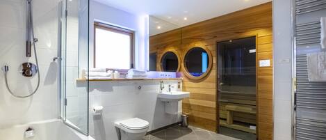 A modern bathroom with a glass-enclosed shower, a white toilet, and a wooden vanity with a sink.