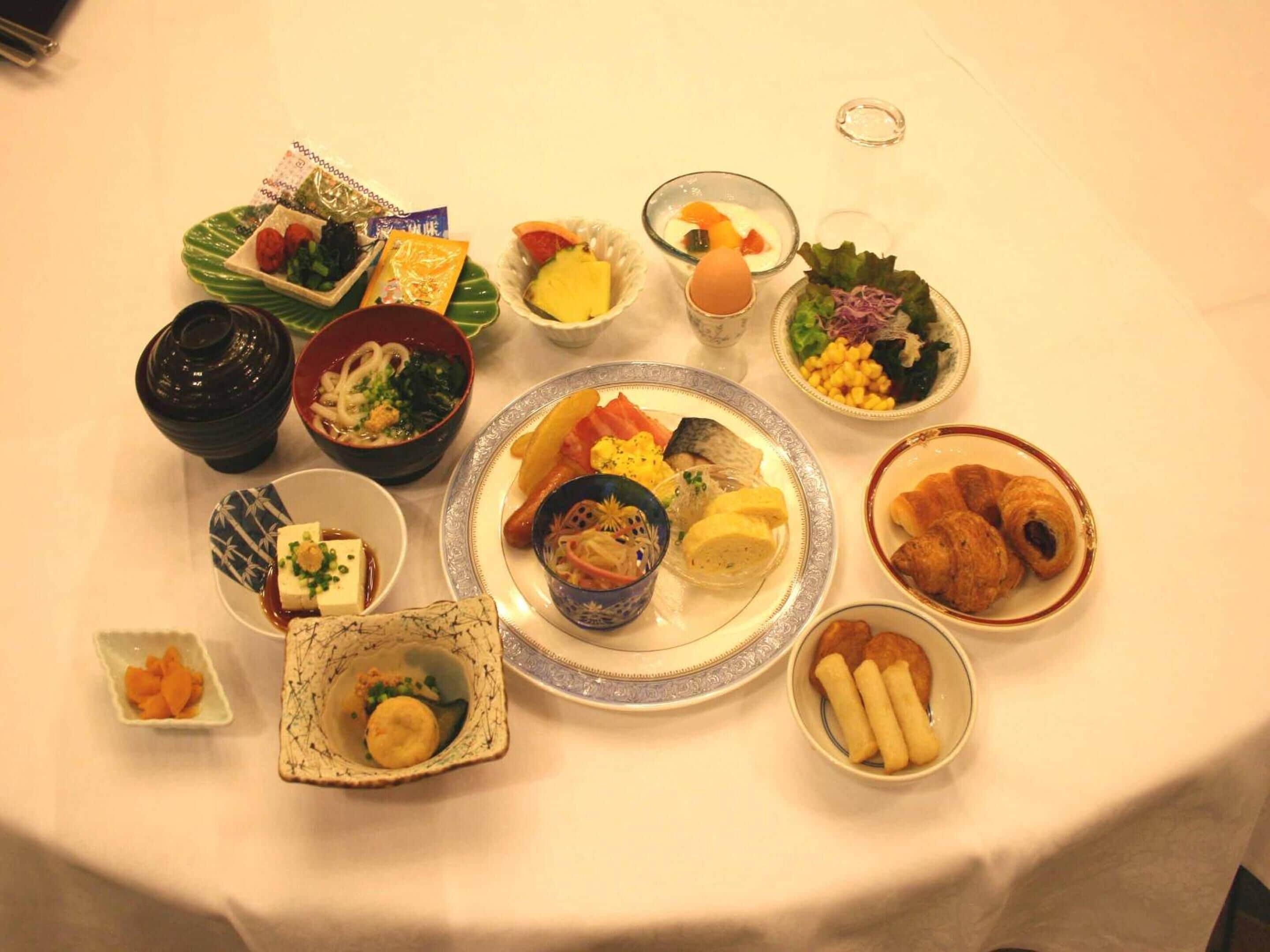 Eine Auswahl an Gerichten auf einem Tisch, darunter Sushi, Sashimi und weitere Spezialitäten der asiatischen Küche.