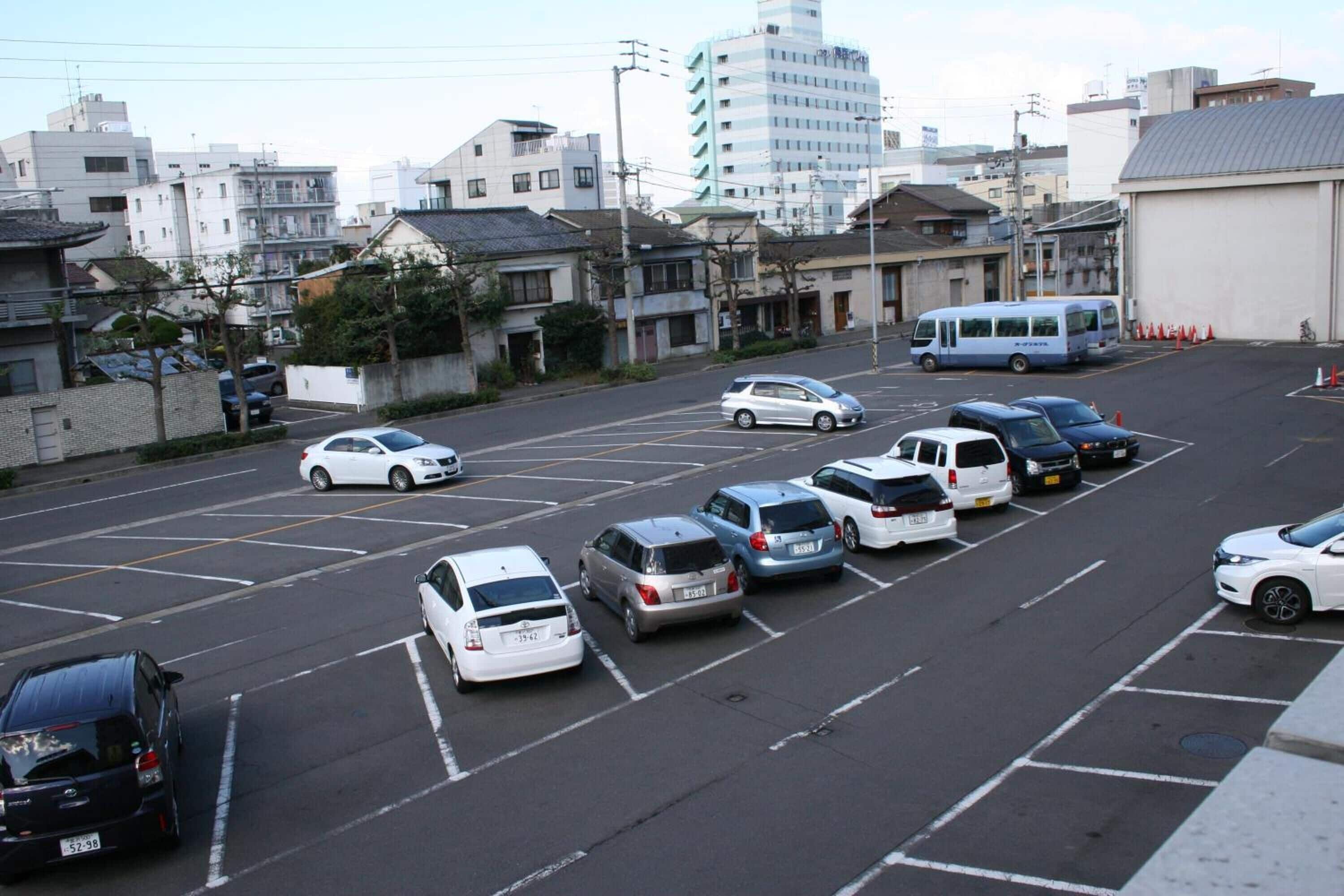 A parking lot with several cars parked in designated spaces.