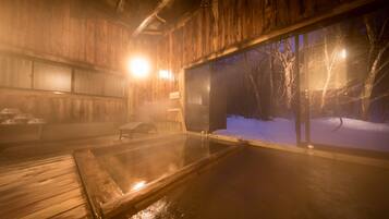 A wooden interior with a large glass window revealing a snowy outdoor scene.