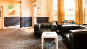 A lobby with black leather sofas, a white coffee table, and a patterned carpet. - Cardiff Riverside Hotel by Belvilla (Cardiff)