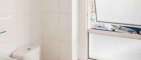Een badkamer met toilet, wastafel en raam.
