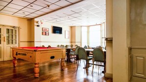 A pool table in a room with wooden flooring, a dining area with chairs, and a door with glass panels. - Cardiff Riverside Hotel by Belvilla (Cardiff)