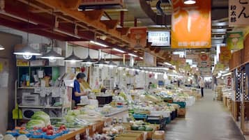 An indoor market with various stalls selling fresh produce and packaged goods.