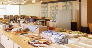 A buffet setup with various food items and dishes.
