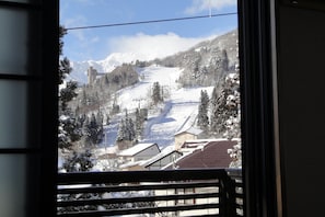 A view of a snowy mountain landscape with buildings and trees.
