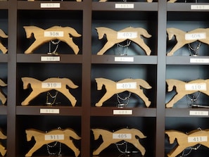 A display of wooden horse-shaped hangers with numbered labels, likely in a store or museum.