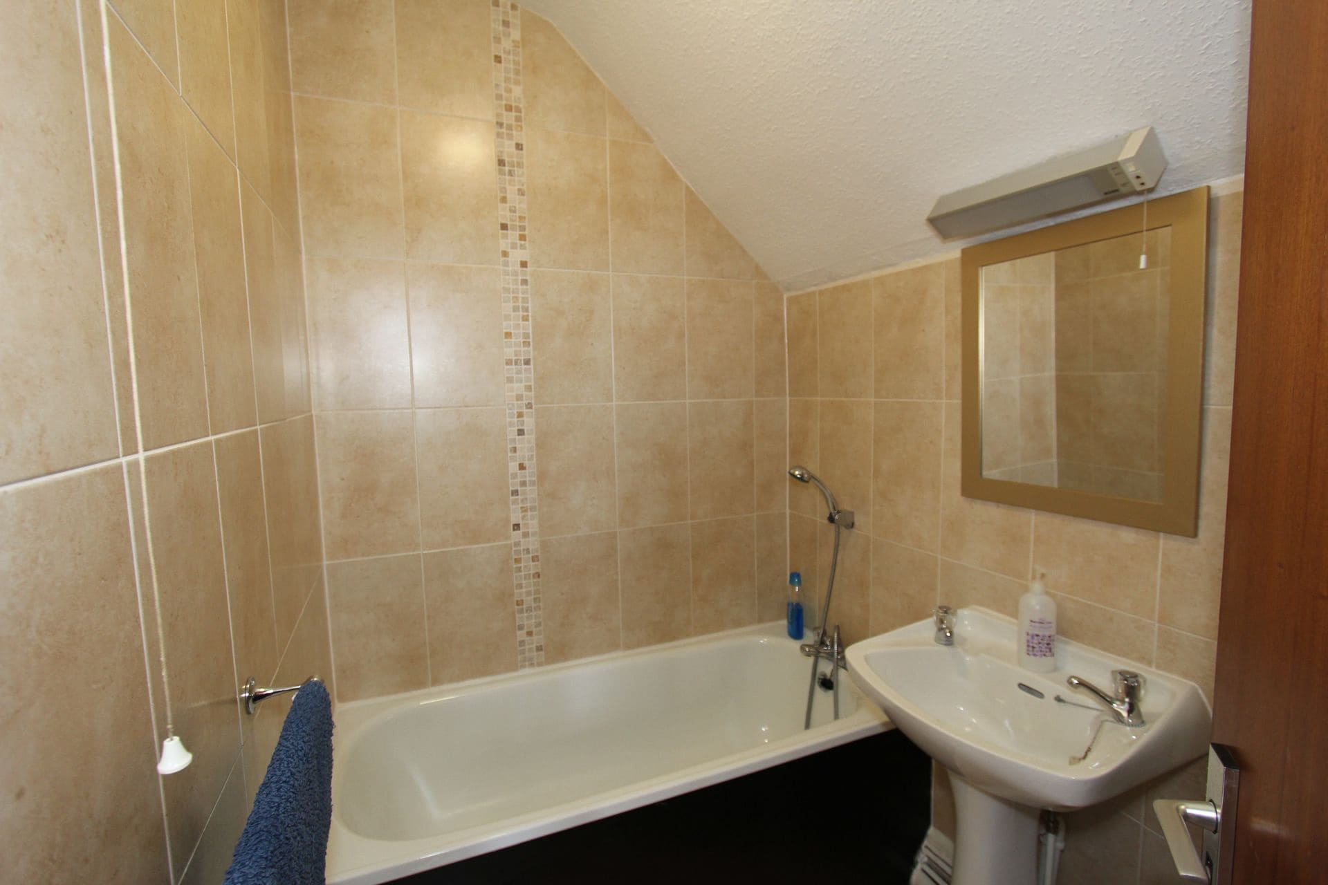 A bathroom with a bathtub, a sink, and a mirror.