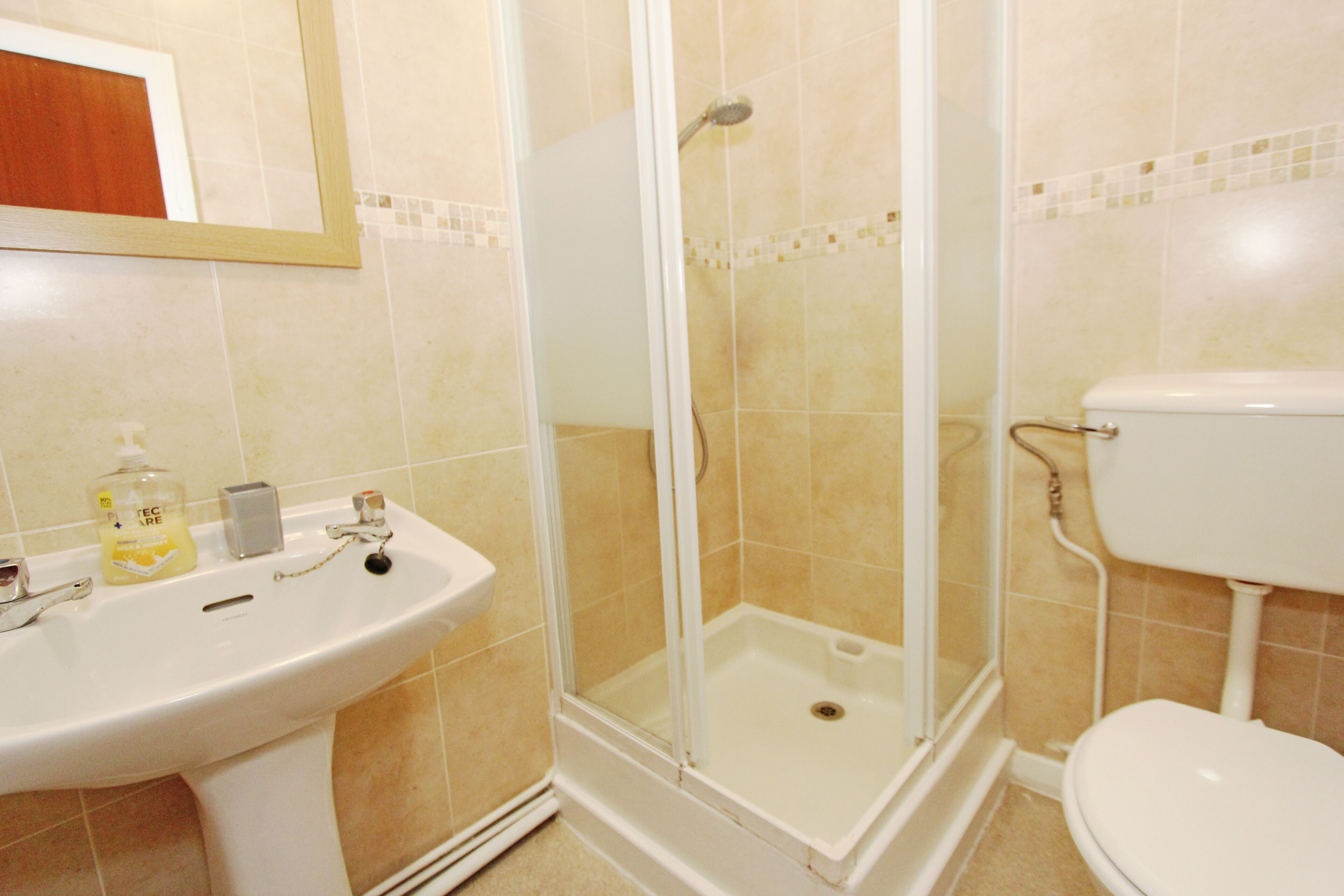 Ein Badezimmer mit Dusche, Waschbecken und Toilette.