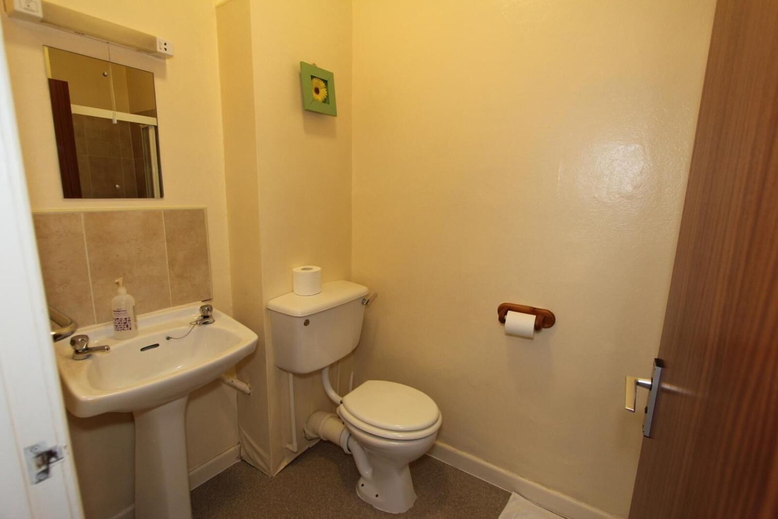 Un baño pequeño con lavamanos, inodoro y espejo.