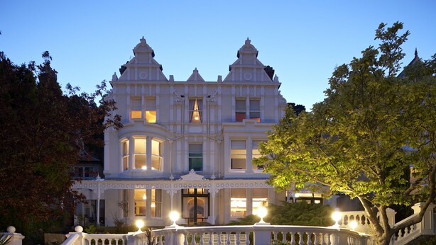 A large, ornate building with multiple windows and a grand entrance, surrounded by lush greenery. - Escape Boutique B&B (Llandudno)