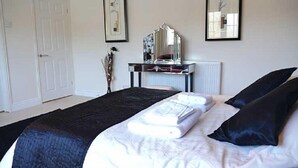Una camera da letto con un letto, un comodino, uno specchio e un termosifone.