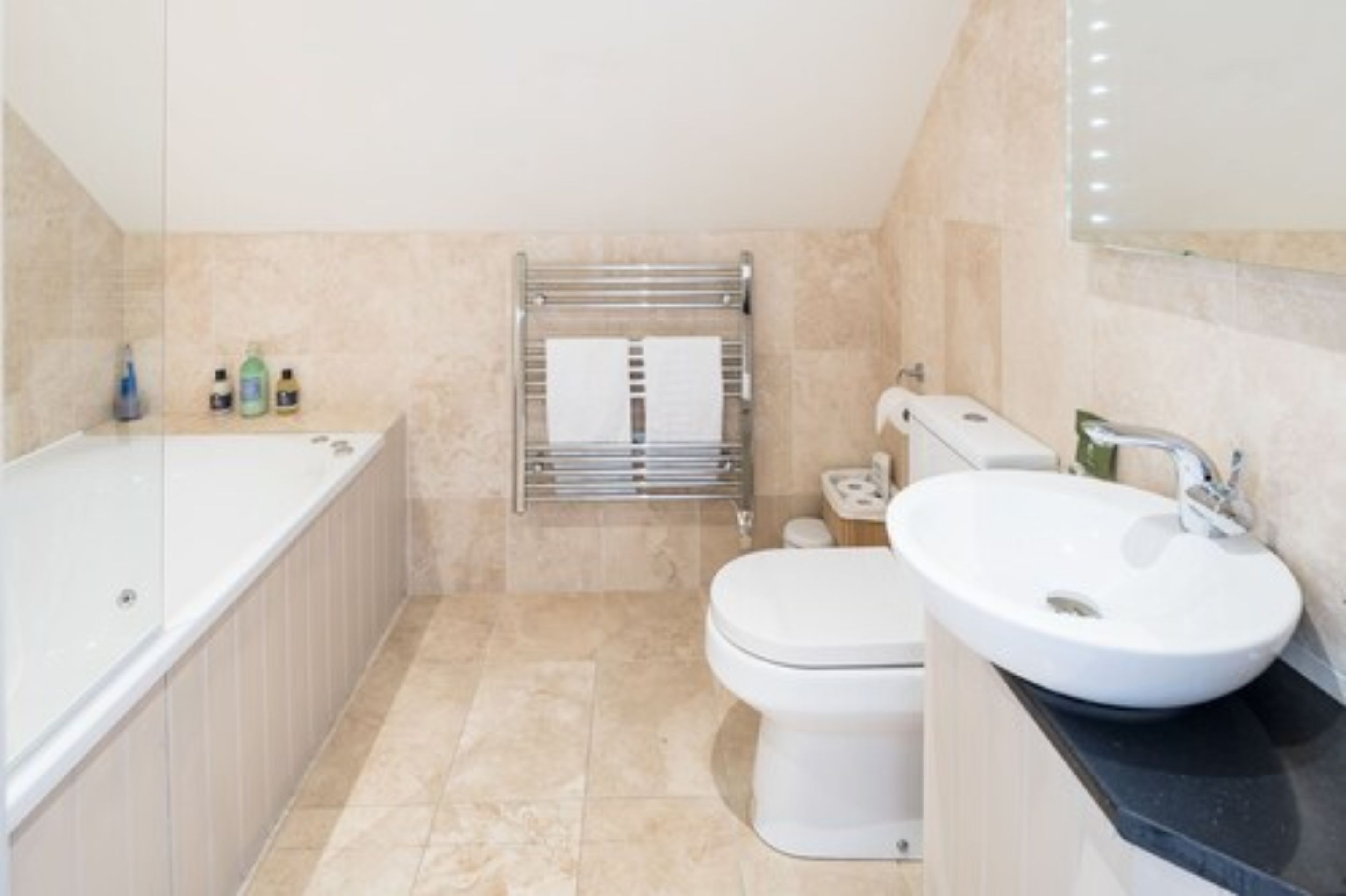 A bathroom with a bathtub, toilet, and sink.