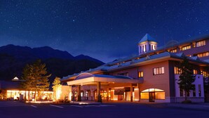 A hotel with a covered entrance, a bell tower, and a mountain backdrop. - TAOYA Kisoji  (Nagiso)