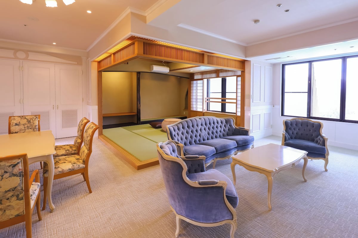 A traditional Japanese-style room with tatami flooring, a low wooden ceiling, and a sliding shoji screen.
