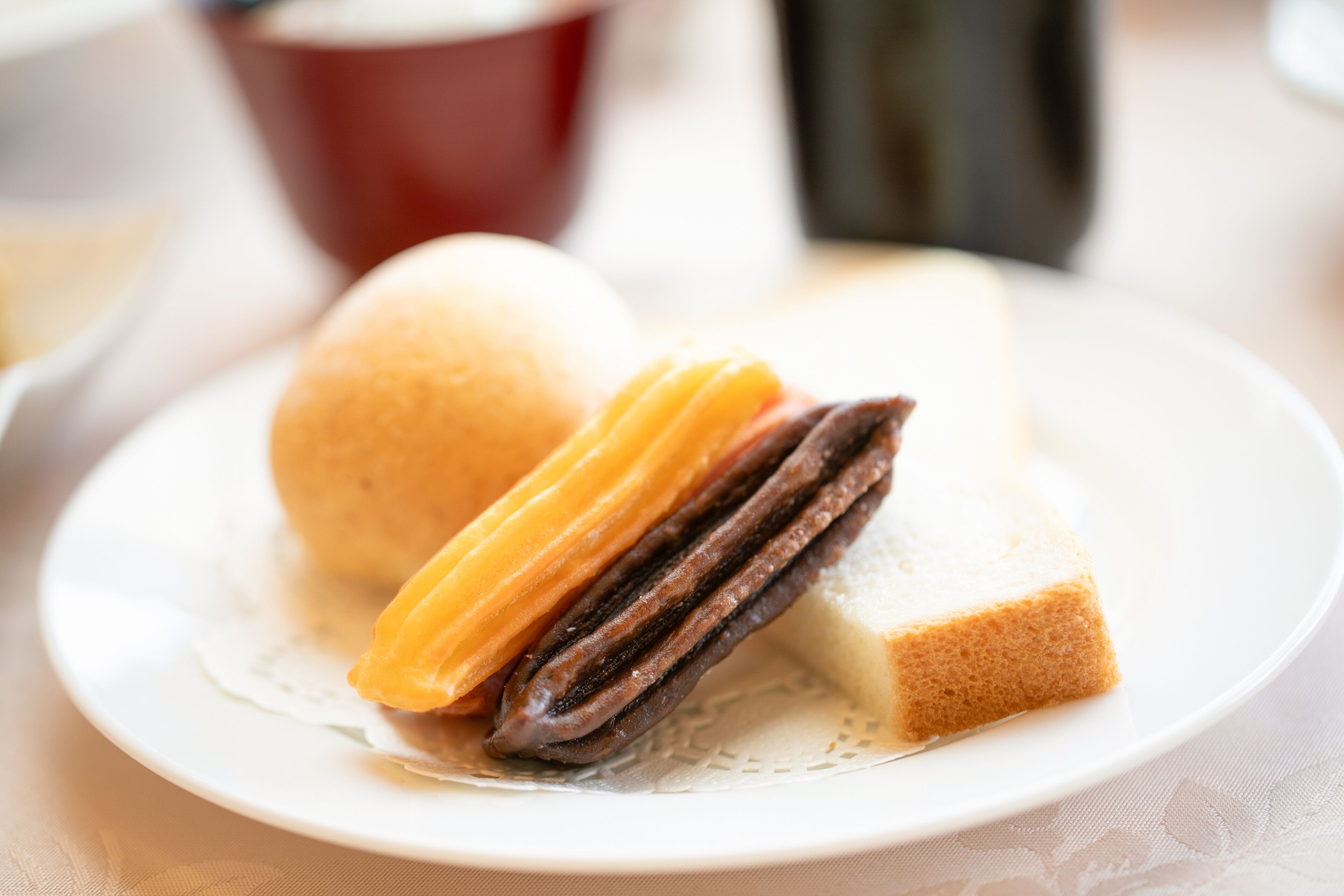 A plate with a sandwich and a pastry.