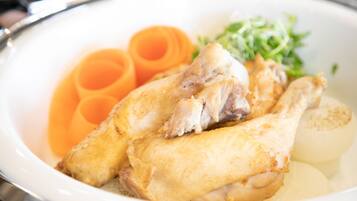 A plate with chicken, carrots, and greens.