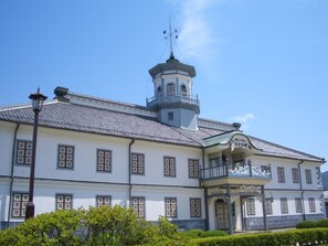 Un bâtiment historique doté d’une tour centrale, de nombreuses fenêtres et d’une entrée abritée.