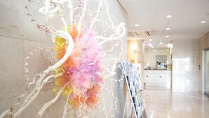A modern interior with a decorative wall installation featuring organic shapes and a color gradient. - Hotel Montagne Matsumoto (Matsumoto)