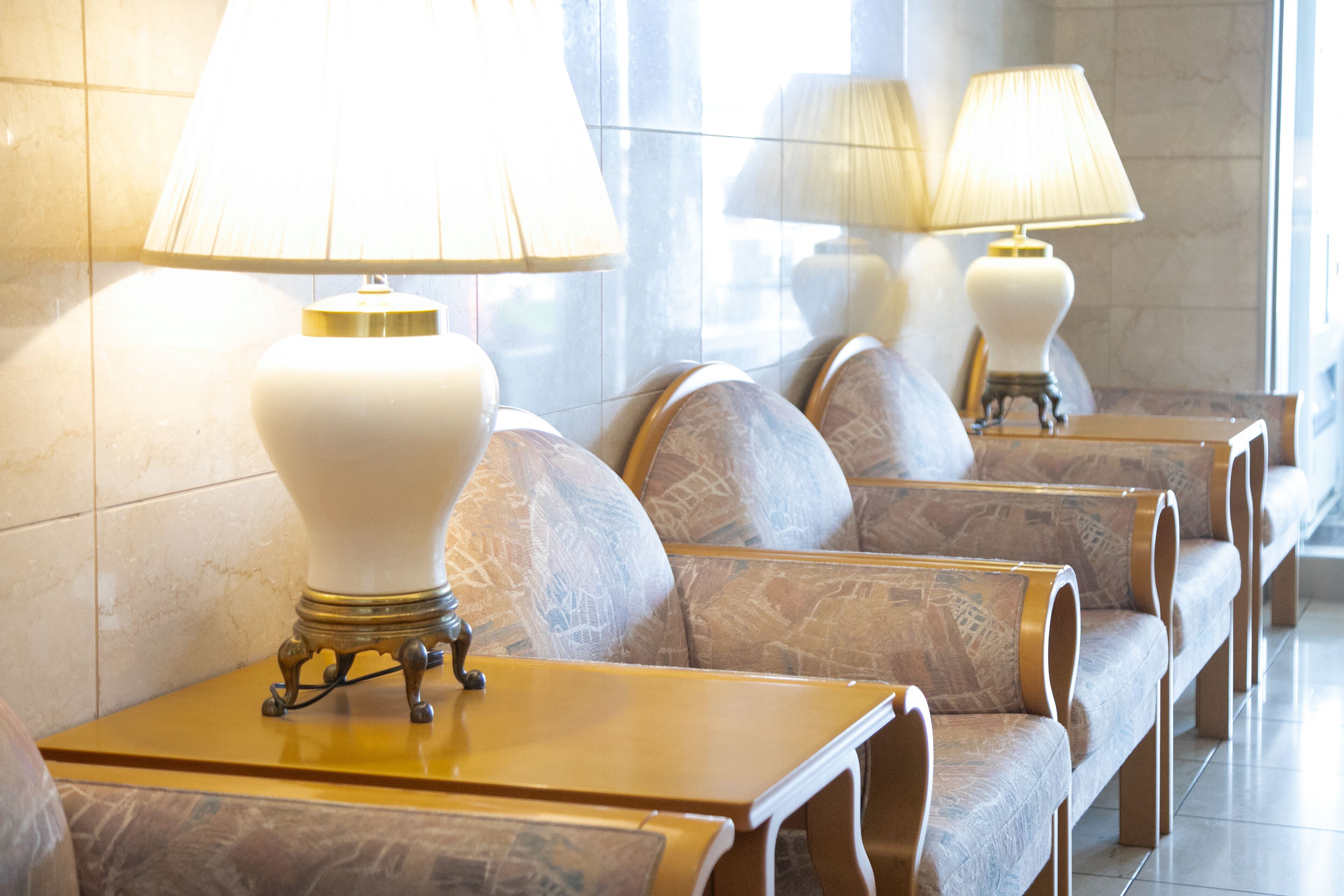Sitzreihen mit Lampen und einer Fliesenwand.