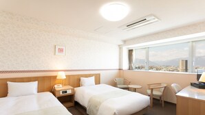 A hotel room with two beds, a desk, a chair, a small table, and a window with a city view. - Hotel Montagne Matsumoto (Matsumoto)
