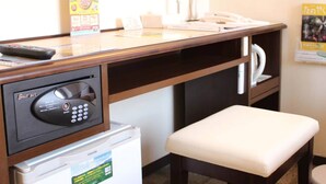 Un mostrador de recepción de hotel con un refrigerador Toshiba, un microondas, un teléfono y una pequeña zona de estar.