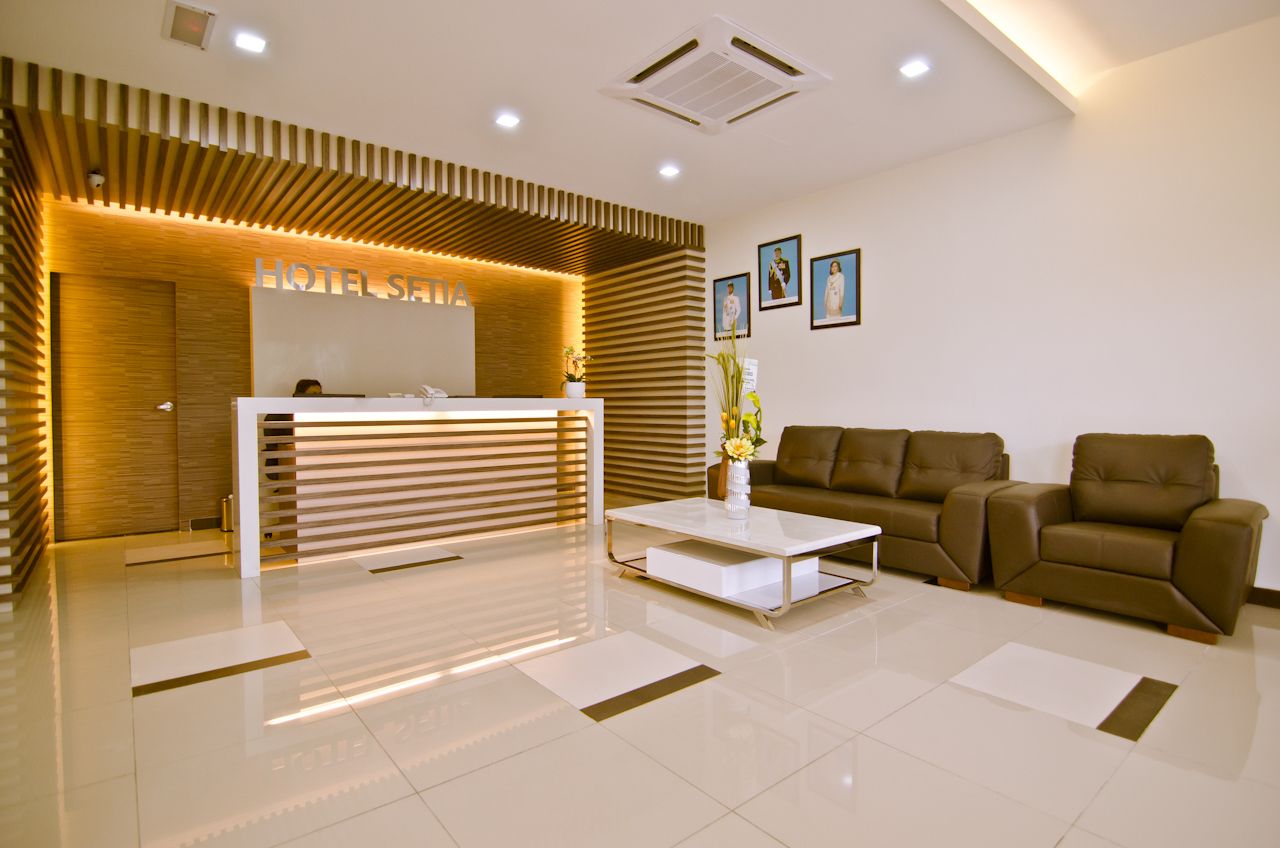 A hotel reception area with a modern design, featuring a reception desk, sofas, and a coffee table.