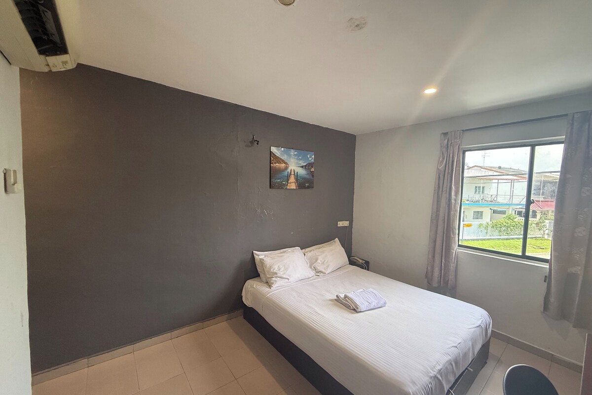 Ein Hotelzimmer mit Bett, einem Vorhangfenster, einem Bild an der Wand und einem gefliesten Boden.