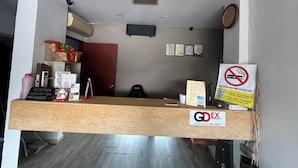 A reception desk with a sign for a delivery service, a clock, and certificates on the wall. - Tiong Nam Hotel Near Pasir Gudang (Pasir Gudang)