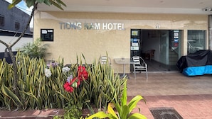 The exterior of Tiong Nam Hotel with a signboard, entrance, and a small outdoor seating area with chairs and tables. - Tiong Nam Hotel Near Pasir Gudang (Pasir Gudang)