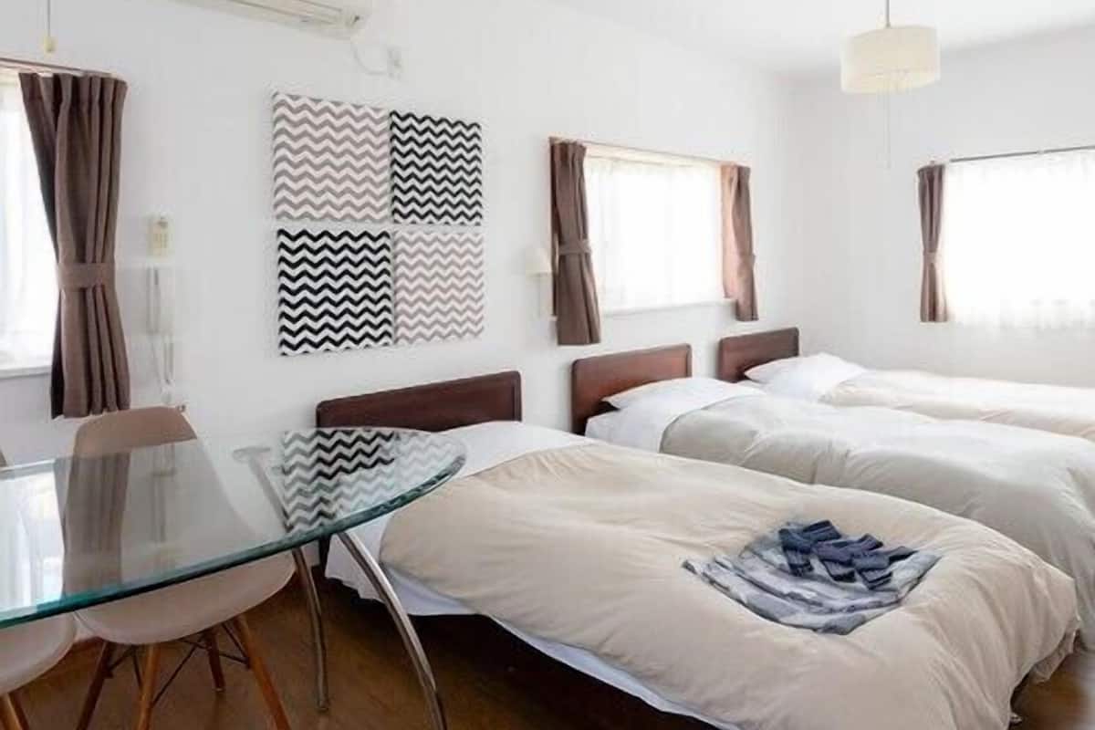 Une chambre d’hôtel avec deux lits, une table en verre et une vue sur la ville.