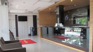 A modern hotel lobby with a reception desk, seating area, and a large window. - Hotel Austin Paradise - Pulai Utama (Johor Bahru)