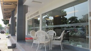 A hotel exterior with outdoor seating and a clear view of the street. - Hotel Austin Paradise - Pulai Utama (Johor Bahru)