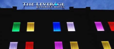 The Leverage Business Hotel with illuminated windows in various colors.