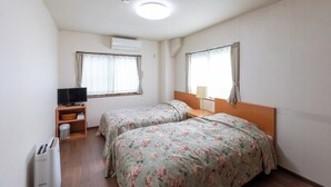 Habitació d'hotel amb dos llits, televisió, làmpada i un calefactor.