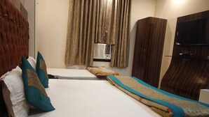 A hotel room with a bed, a wardrobe, a television, and a window with curtains. - Indo Continental (Delhi)
