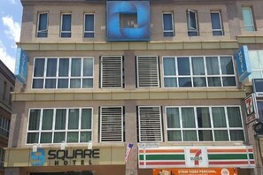 Experience the SQUARE HOTEL's modern architecture with large windows and a flat roof.