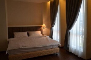 Restful retreat with a quilted mattress and pillow, set against a simple headboard and bedside lamp.