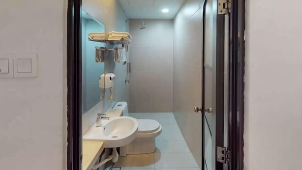 A modern bathroom with a toilet, sink, and shower.