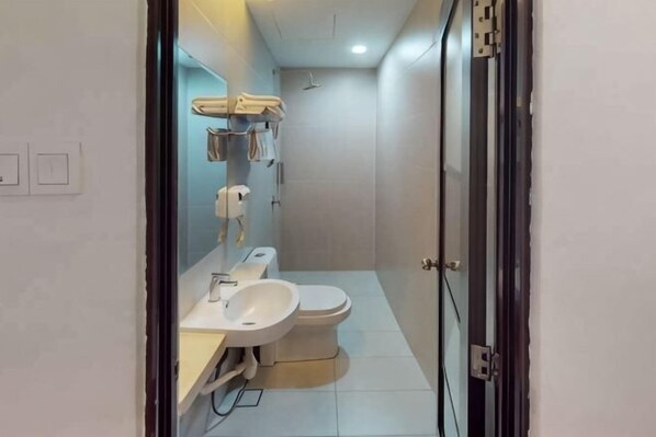 Une salle de bain moderne équipée de toilettes, d’un lavabo et d’une douche.