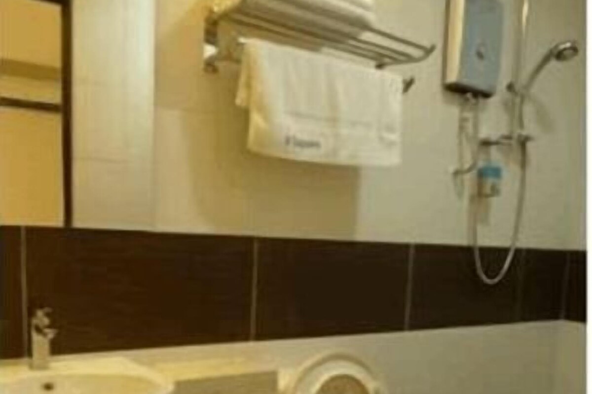 A bathroom with a toilet, sink, and shower.