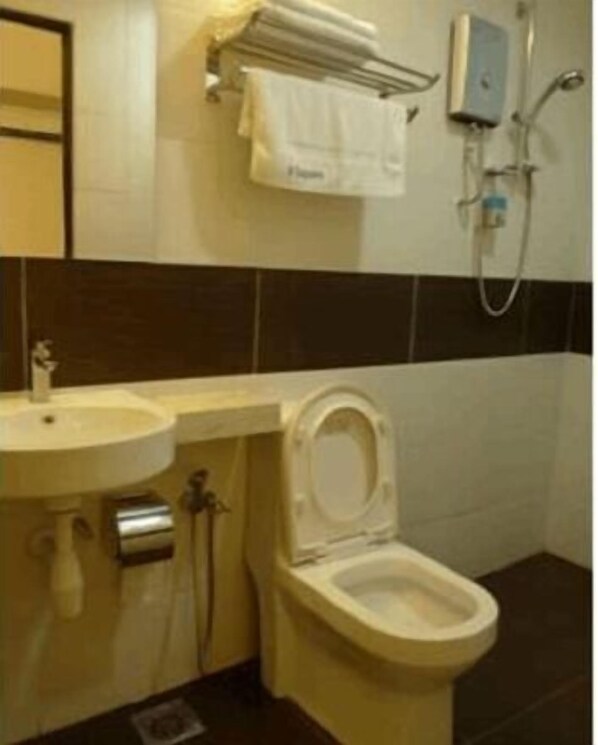 A bathroom with a toilet, sink, and shower.