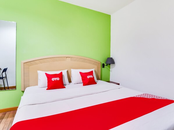 A hotel room with a bed, green walls, and a red and white bedspread. - OYO 89652 Bjorn Boutique Hotel (Kuala Lumpur)