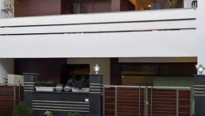 A modern building with a flat roof, a gated entrance, and a balcony. - Red Maple Bed & Breakfast (New Delhi)